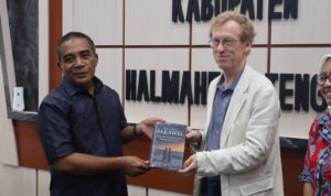 Wakil Bupati Ahlan Djumadil bertukar buku dengan Direktur Ford Foundation Anthony Bebbington saat berkunjung di kantor bupati Halteng. (Foto: Dok. Ist)